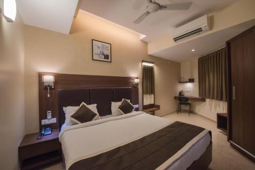 um quarto com uma cama grande num quarto de hotel em Hotel Inland Avenue em Mangalore