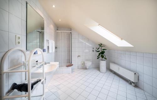 a white bathroom with a sink and a mirror at Sunibel Inn in Reinheim