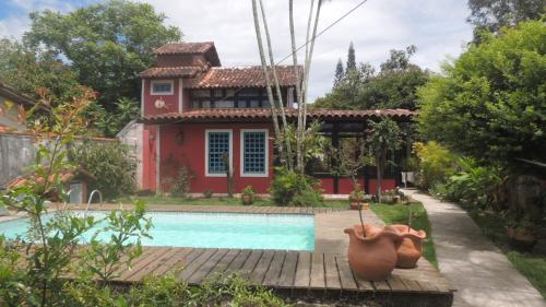 una casa con piscina frente a una casa en Pousada Maria da Toca, en Rio das Ostras