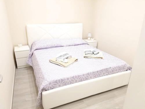 a white bedroom with a bed with two towels on it at Charming apartment in Canicatti, 40 m² with private terrace. in Canicattì