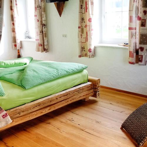 a bedroom with a bed with green sheets and a window at Kerndlerhof in Ybbs an der Donau