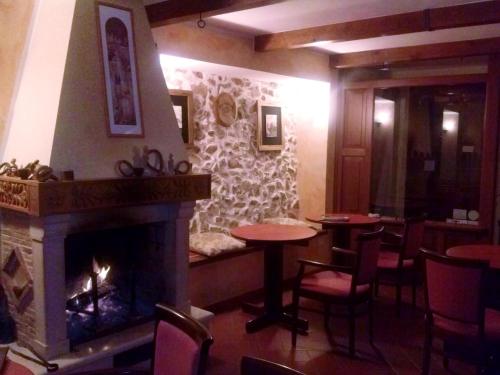 a fireplace in a restaurant with tables and chairs at Garnì B&B La Rua-Pescocostanzo in Pescocostanzo