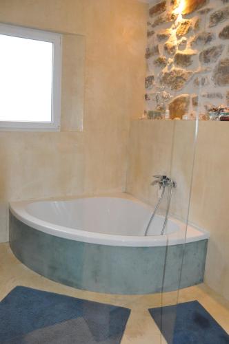 a bath tub in a bathroom with a window at Un petit coin de paradis in Le Péage
