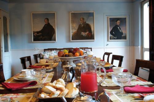 a dining room table with food and portraits on the wall at Guest House Arco Dei Tolomei in Rome