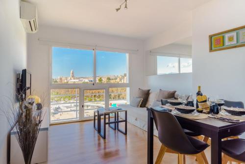 a kitchen and living room with a table and chairs at LU&CIA Málaga Skyline in Málaga