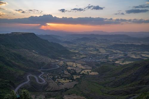 a view of a mountain valley with a winding road at Panoramic View Hotel in Lalībela