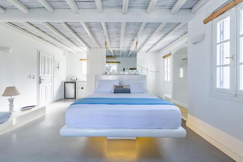 a large white bedroom with a large white bed at Evlalia Studios & Villas in Skopelos Town