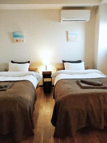 a hotel room with two beds and a lamp at Sun Hotel in Tokyo
