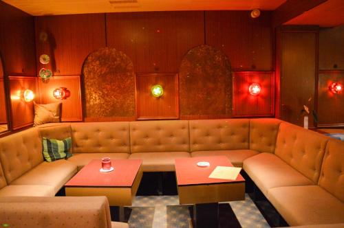 a restaurant with a couch and a table in a room at CAREA Residenz Hotel Harzhöhe in Hahnenklee-Bockswiese