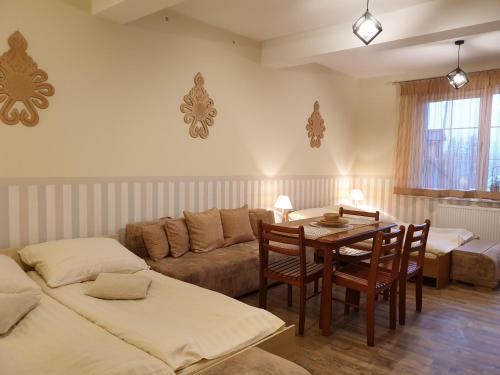 a living room with a table and a couch at Willa Baca in Duszniki Zdrój