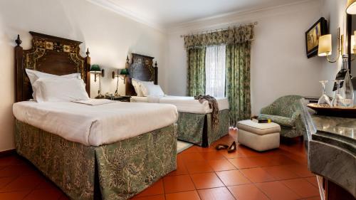 um quarto de hotel com duas camas e um sofá em Pousada de Marvao em Marvão