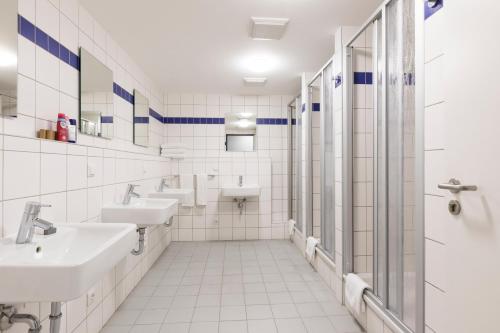 a bathroom with two sinks and two mirrors at mk monteurzimmer eschborn in Eschborn