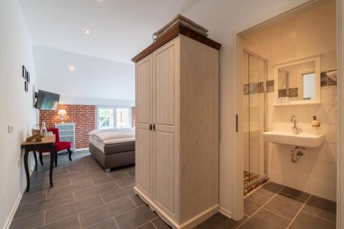 a bathroom with a sink and a cabinet with a sink at Insel-Land-Hotel Michaelsen in Borkum