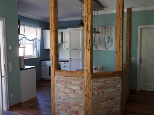a kitchen with white cabinets and a brick wall at Pferdehof Bela in Nonnevitz