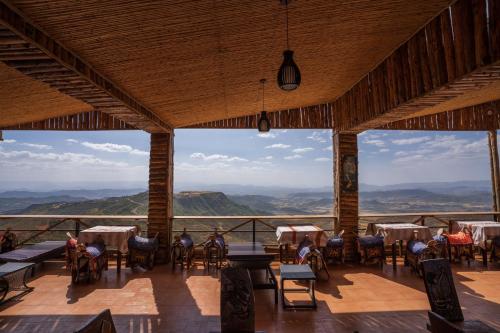 a restaurant with tables and chairs and a view of the mountains at Panoramic View Hotel in Lalībela