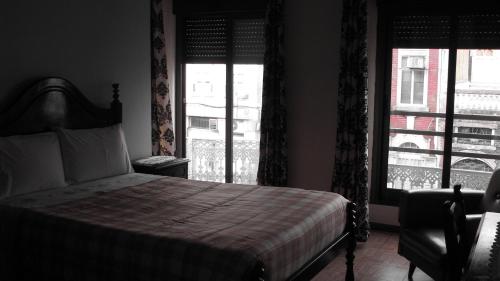 a bedroom with a bed and a large window at Residencial Porto Novo - Alojamento Local in Porto