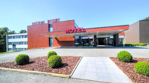 a hotel with bushes in front of a building at Hotel & Aparthotel Casteau Resort Mons Soignies in Casteau