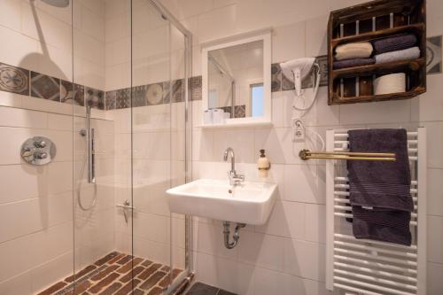 a bathroom with a sink and a shower at INSEL-LAND-HOTEL MICHAELSEN im November Morgen-Yoga u Sauna inkl in Borkum