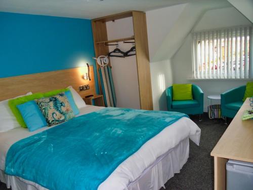 um quarto com uma cama grande e paredes azuis em The Beaucliffe em Blackpool