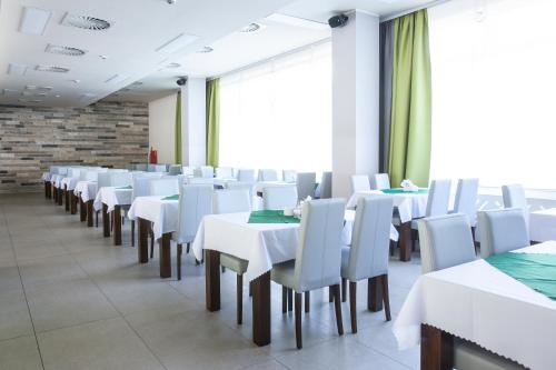 a dining room with white tables and chairs at Ośrodek Delfin Rewita in Jurata