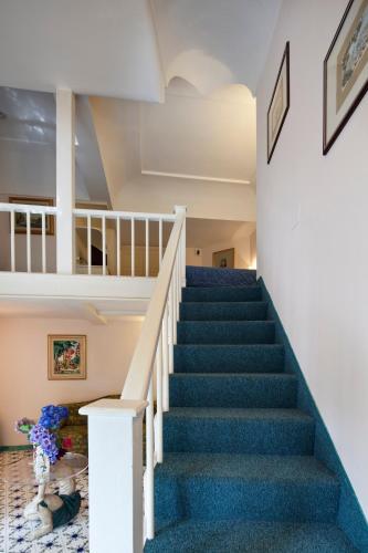 a staircase in a house with blue carpet at Hotel Continental Ischia in Ischia