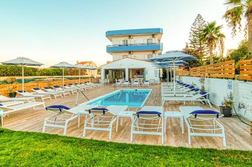 a pool with chairs and umbrellas next to a building at Emi Seaside in Amoudara Herakliou