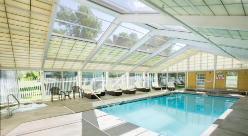 an indoor swimming pool with a glass ceiling at The Yankee, Trademark Collection by Wyndham in Lenox