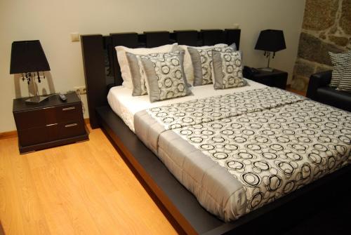 a bedroom with a large bed and a night stand at Quinta Do Passal in Paços de Ferreira