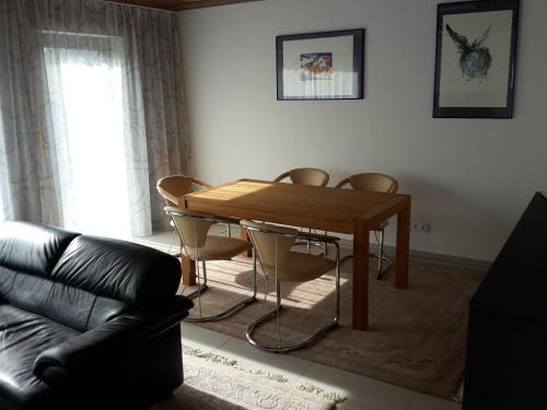 sala de estar con mesa de madera y sillas en Haus Rangau für Ferien-und Messen, en Wendelstein