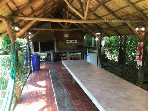 a picnic table under a wooden roof in a patio at Rio Manso Tigre in Tigre