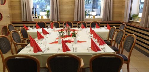a table with red napkins on it in a room at Schollers Restaurant & Hotel in Rendsburg