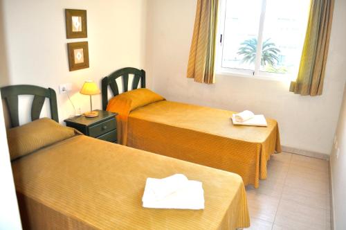 Tempat tidur dalam kamar di Palm Beach, 2 dormitorios, playa 50m, by Bookindenia