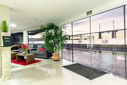 a living room with a couch and a large window at WR Confort Hotel Campo Grande in Campo Grande