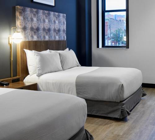 a hotel room with two beds and a window at TRYP by Wyndham Pittsburgh/Lawrenceville in Pittsburgh