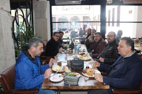 Un gruppo di uomini seduti a tavola che mangiano cibo di Yazmacılar Hanı Otel Restaurant a Tokat
