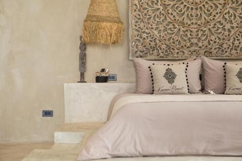 a bedroom with a bed with a headboard and pillows at Karma Resort in Bophut 