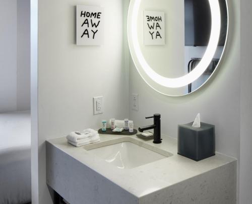 a bathroom with a sink and a mirror at TRYP by Wyndham Pittsburgh/Lawrenceville in Pittsburgh