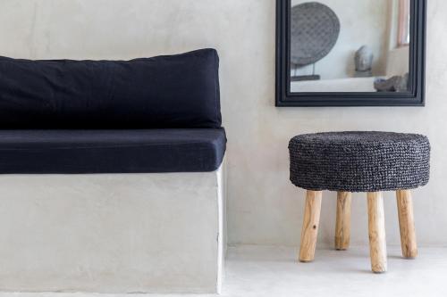 a couch and a stool next to a mirror at Karma Resort in Bophut 