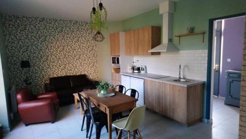 une cuisine et un salon avec une table et un canapé dans l'établissement Le jardin des Écureuils, à Démuin
