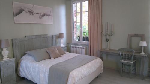 um quarto com uma cama, uma mesa e uma cadeira em Le jardin des Écureuils em Démuin