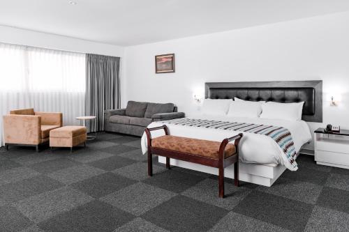 una camera d'albergo con un grande letto e un divano di Costa del Sol Wyndham Tumbes a Tumbes