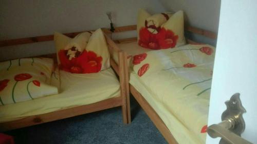 2 Einzelbetten in einem Zimmer mit Blumen darauf in der Unterkunft Ferienwohnung Marion Franke in Weimar