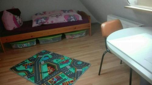 ein kleines Zimmer mit einem Bett, einem Tisch und einem Stuhl in der Unterkunft Ferienwohnung Marion Franke in Weimar