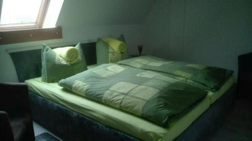ein großes Bett in einem Schlafzimmer mit Fenster in der Unterkunft Ferienwohnung Marion Franke in Weimar