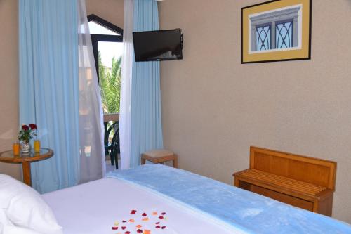 a bedroom with a bed and a television and a window at Hôtel Atlantique Panorama in Safi