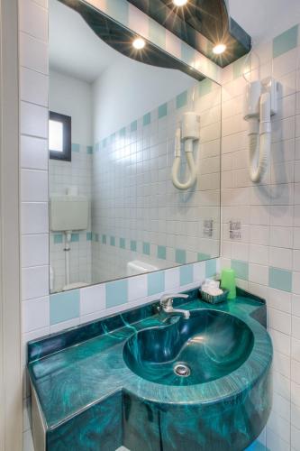 a bathroom with a blue tub with a mirror at Hotel Nautico in Cattolica