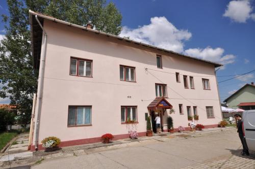 a large white building with windows and a porch at Kalcit Tourist Motel in Bélapátfalva