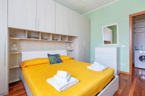 - une chambre avec un lit jaune et des serviettes dans l'établissement Savona District Terrace Flat, à Milan
