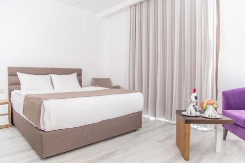 a bedroom with a large bed and a purple couch at Hotel Sun in North Nicosia
