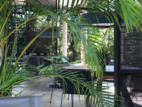 a patio with tables and chairs and palm trees at KAJU GREEN eco lodges in Unawatuna